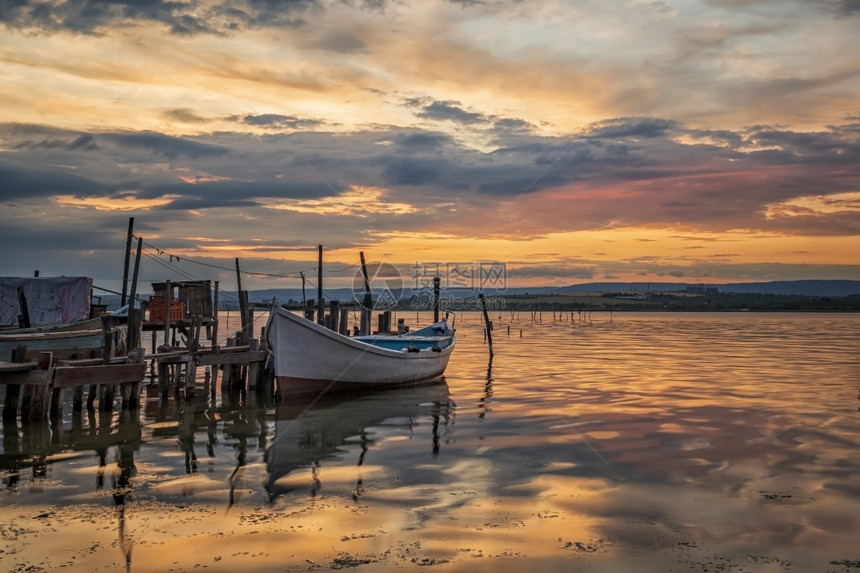 黄昏美丽的云景在湖边木码头有船的湖边令人惊异的多彩日落图片