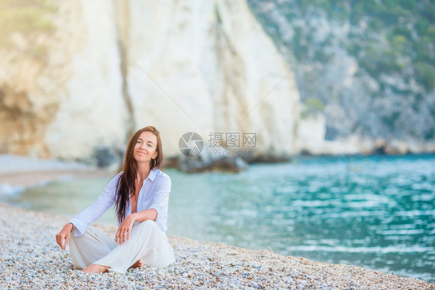 自然丰富多彩的海滩上美丽放松女人白色热带海滩上的年轻美丽女人采取图片