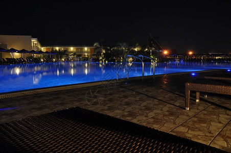 黑暗的晚上在豪华酒店的游泳池户外旅图片