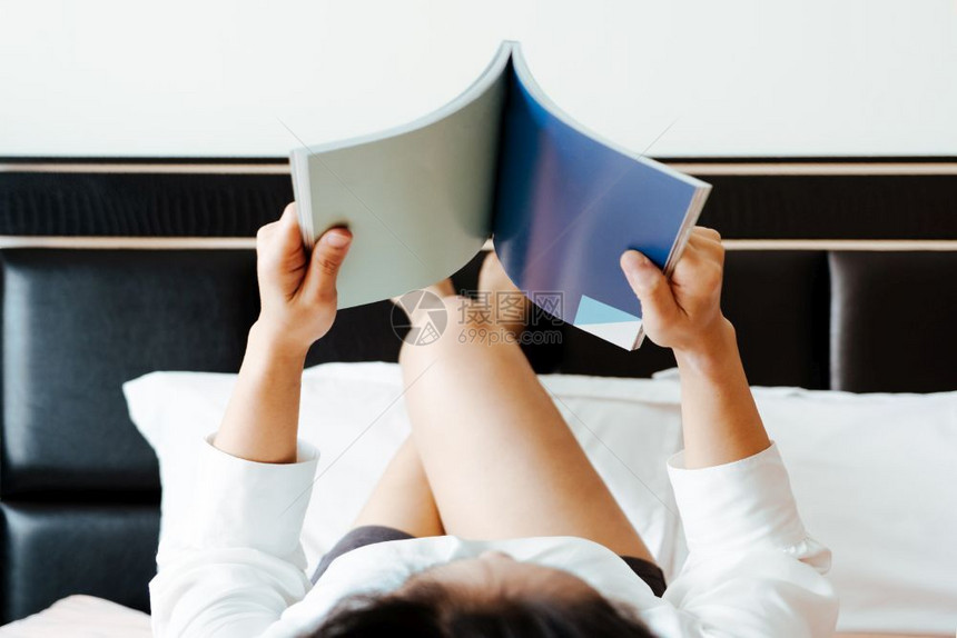 休息女人躺在床上看空书的可爱读图片
