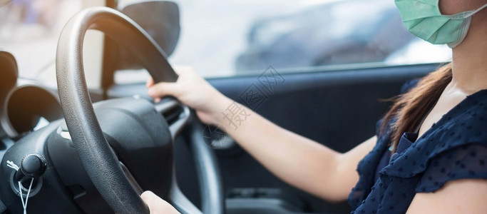 戴口罩的年轻女性驾驶汽车图片