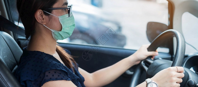 戴口罩的年轻女性驾驶汽车图片