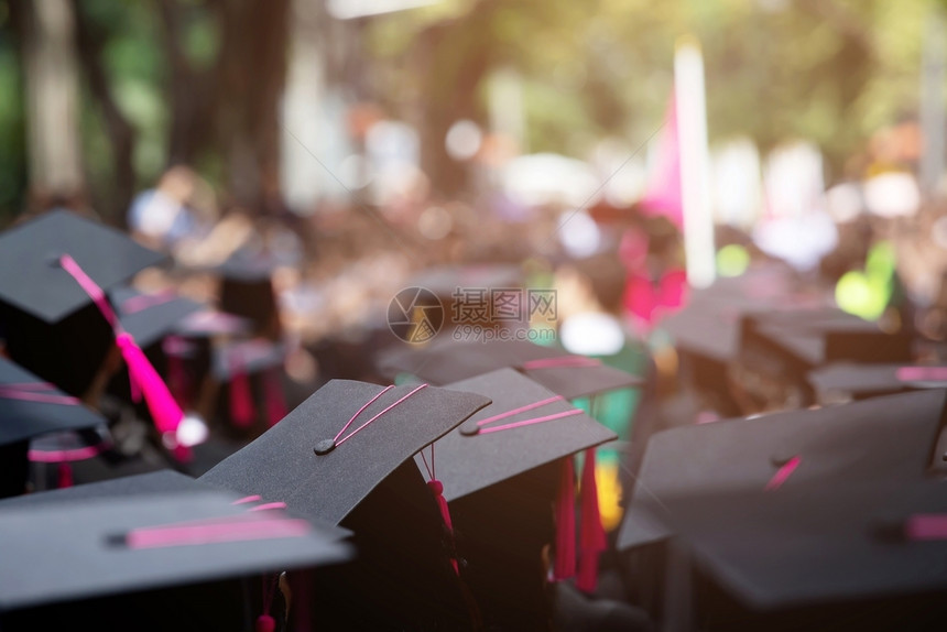 帽子年轻的知识在大学毕业典礼上祝贺获得大学位以粉红色为焦点的粉红号帆船在大学毕业仪式上祝贺图片