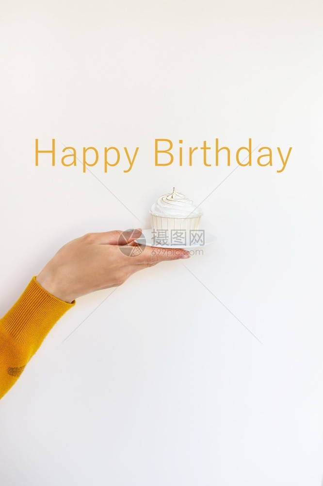 烘烤的小雨持有一只女手拿着个美味的纸杯蛋糕祝贺生日快乐刻字一只女手拿着个美味的纸杯蛋糕祝贺生日快乐图片
