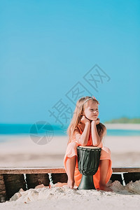 沙滩上玩鼓的小女孩图片