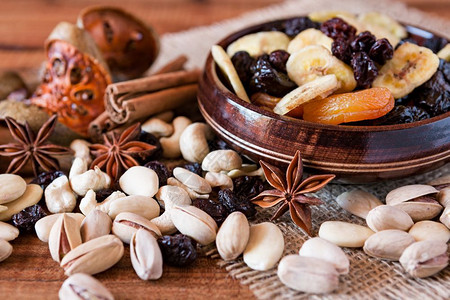 异国坚果食物核桃木制的将干果混合在木质碗里坚果混合在生锈的桌边并将干果和坚混合在一起背景