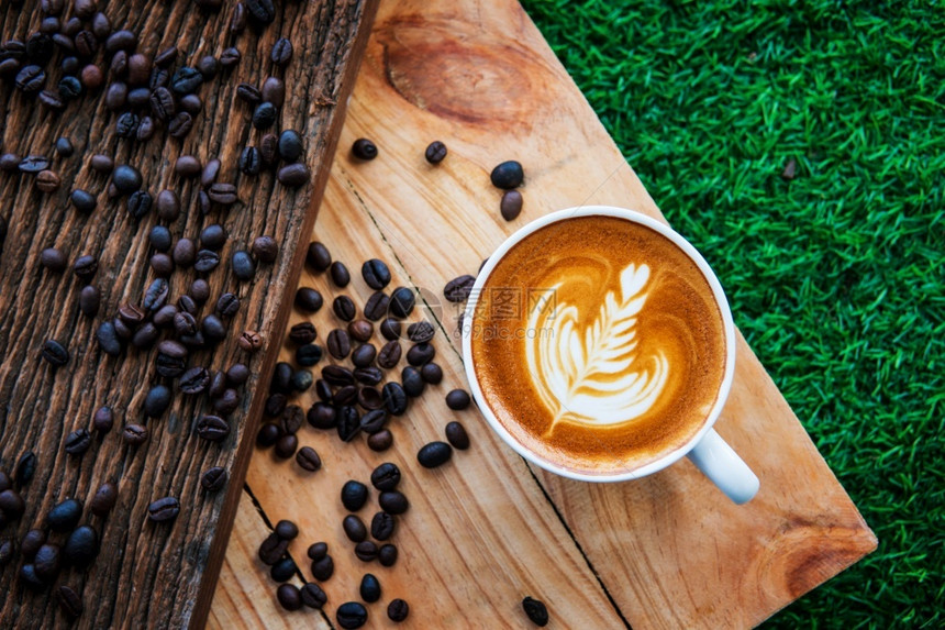 白色的卡布奇诺咖啡和豆在木材纹理背景早晨或咖啡时间餐商业有机的图片