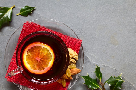 核桃橙圣诞节重点树叶拍照玻璃杯顶上涂满橙色红葡萄酒侧面有冬利叶用自然光拍下板上的头部选择焦点聚混音葡萄酒背景