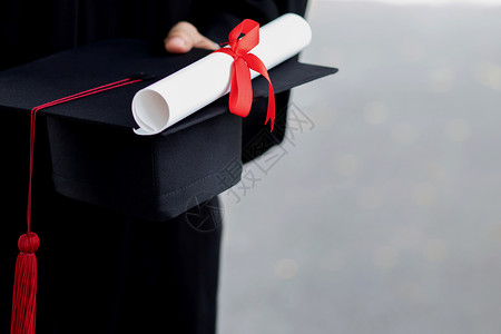 红色毕业帽子结业关闭学生持有帽子和手红袜的学生在大毕业成功生的入校仪式期间受孕教育祝贺毕业典礼掌声年轻的商业学校背景