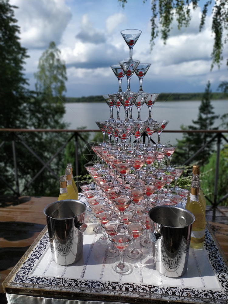 香槟滑梯由带樱桃的香槟杯制成金字塔或喷泉由带樱桃的香槟杯制成金字塔或喷泉红色的酒精浆果图片
