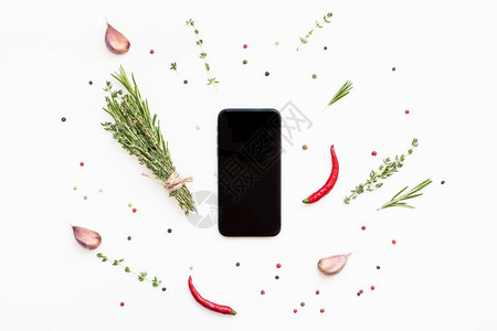 博客素材素材空白的迷迭香勺子色背景的智能手机模拟假冒空白文本间带绿色草药和香料菜单设计食品博客谱烹饪手册或配有素材的送餐程序背景