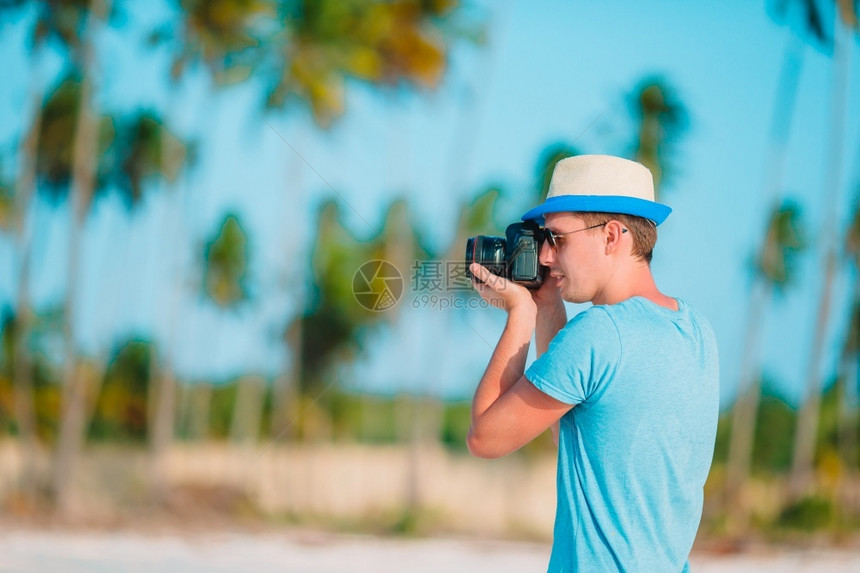 男子在白色沙滩拍摄美丽的海景图片