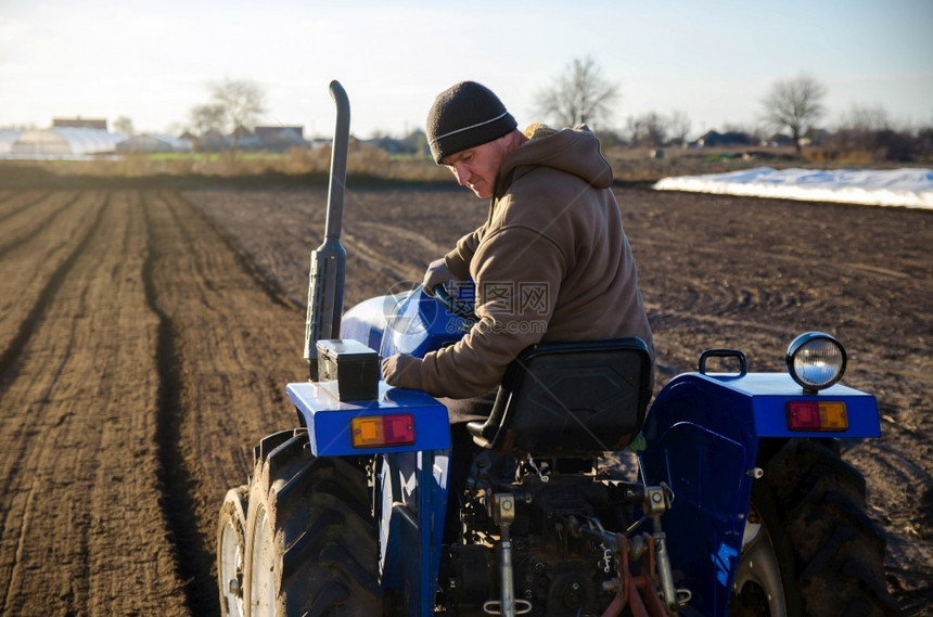 土壤一种高级农民在拖拉机上耕种田地季节工人招聘从事农业机械工作土地耕农业小场村景业务栽培图片