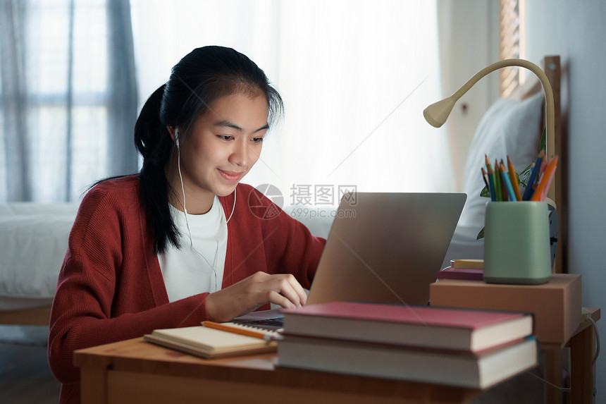 亚裔女孩在晚上坐卧室睡觉时学习在家上线校对PortnoyibleNationallifywn会议电脑互联网图片