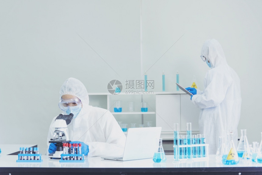 蓝色的科学家covid19抗体研究实验室生物技术培育抗疫苗科学家看显微镜实验室科学试管化实验室冠状新图片