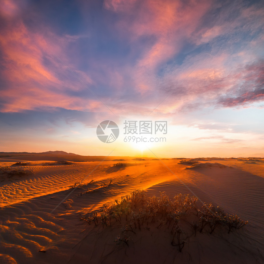 云户外天气在干旱沙漠地貌的令人惊叹日落之夜天空下对孤单沙丘的触目惊艳景色图片