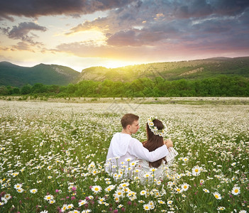 快乐的可爱一对夫妇在菊花草地自然和浪漫的场景观白色图片