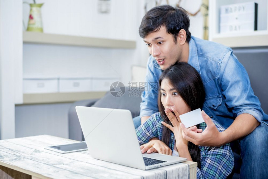 购买网络信用使笔记本电脑的家庭概念恋人技术时爱人是令惊讶的图片