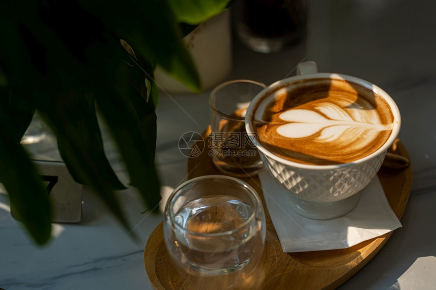 心咖啡厅店的里茶杯子和大理石地板背景桌上的大理石咖啡师饮料图片