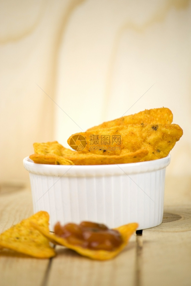 胡椒脆的黄色辣玉米饼薯片和番茄沙拉酱泡在木板上图片