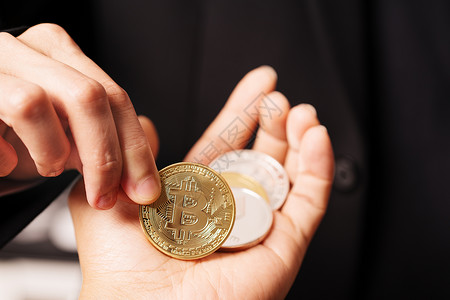Bitcoin手持加密货币硬的女子持有Bitcoin金币投资区块链图片