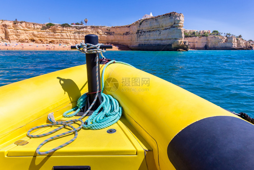黄橡胶船驶向海岸岩石的黄橡皮船地中海阿尔加维欧洲图片