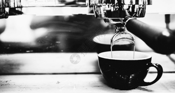 喝浓缩咖啡机冲泡倒入店的玻璃杯中浓缩咖啡从机中倒出光滑的咖啡因图片