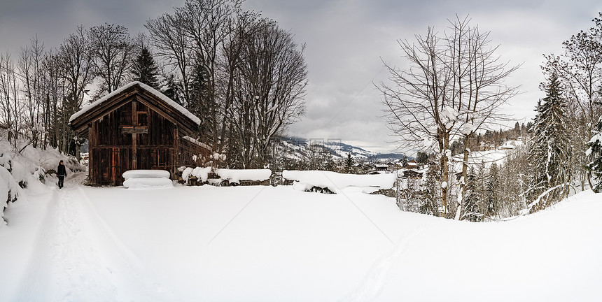 在一个小村落的雪地里所有东西都覆在雪中游客健康锻炼图片