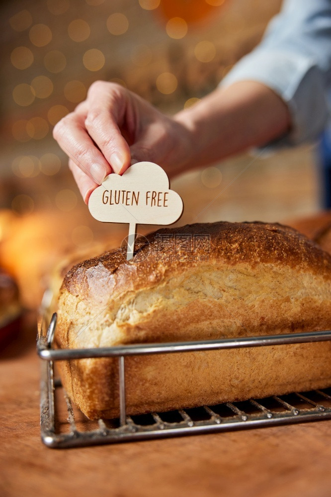 咖啡自由面包店的销售助理将无麸质标签放入新鲜出炉的无麸质酵母面包中饮食图片
