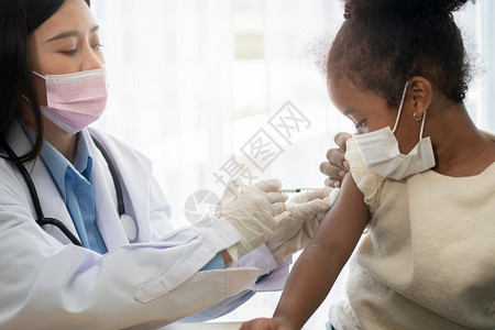 医生使用注射疫苗的针头给儿童接种图片