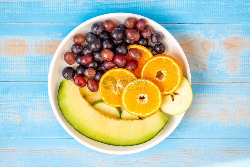 早餐卡路里白中的黑葡萄红巴伦西亚橙子和瓜水果蓝木桌的白菜食用健康的品和保概念间歇图片