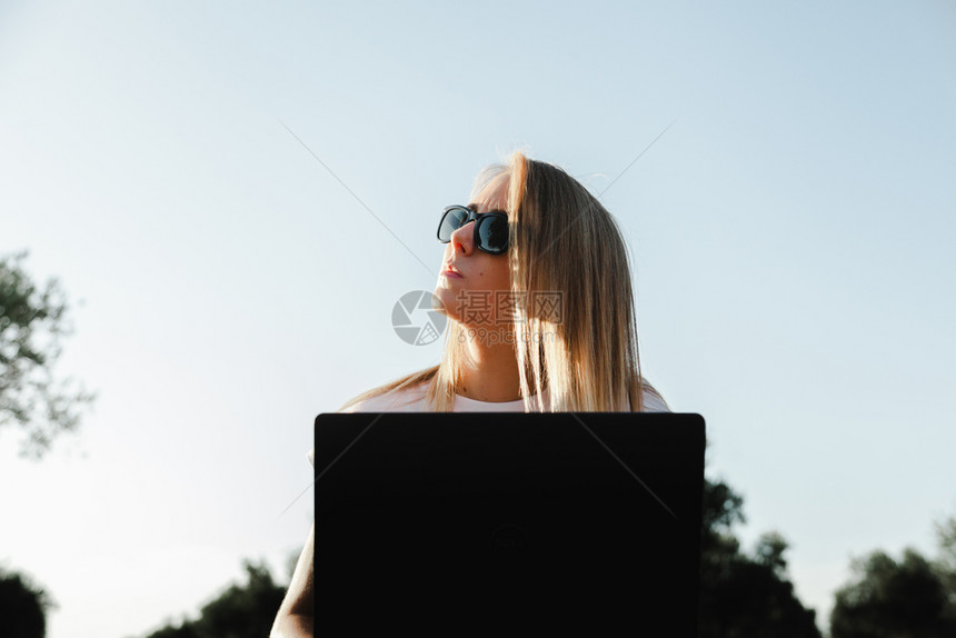 坐在橄榄树田里的拥有笔记本电脑的年轻妇女生物学家习工程师图片
