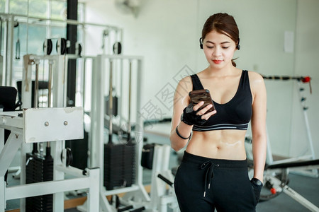 健身房拿着手机的青年女子图片