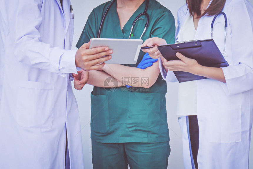 磨砂关心医生和护士在平板设备上检查病人信息讨论图片