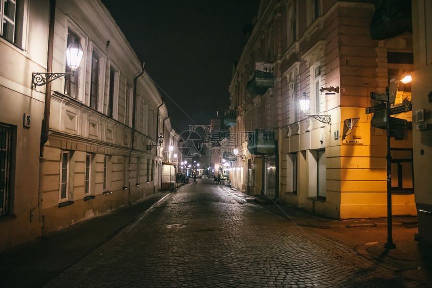 古老的狭窄夜晚有旧建筑和冬季背景的维尔纽斯街历史的欧洲灯图片