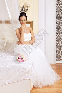 魅力穿着婚纱坐在床上的年轻美女豪华孩图片