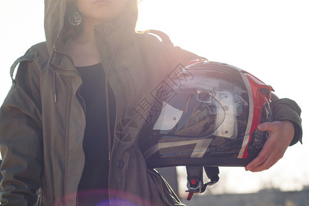 感的漂亮女孩有定制摩托车头戴盔手拿着背蓝皮景的漂亮女孩白种人士图片
