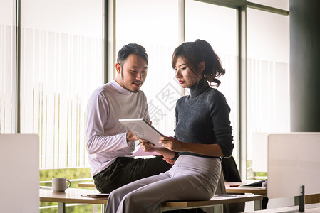 男人和女在开办公室使用平板电脑的创业办公室笔记本电脑坐着图片