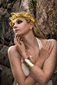 气质女神倪妮美丽的化妆品女孩身着白色外衣和古董珠宝背面有岩石墙女宝士背景