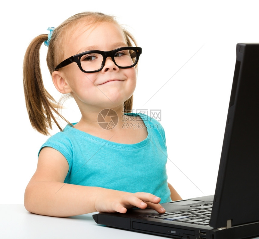 剪下可爱的小女孩坐在桌子上带着黑色笔记本电脑戴着眼镜在白色之上被孤立微笑无线的图片
