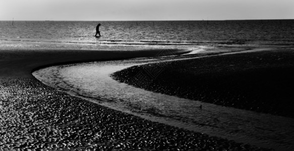 天在海边行走低头和悲哀概念沙滩与弯曲的上行走微小孤独男子简影能够场景图片