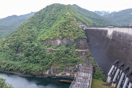 绿色景观湖泰国北部河谷雨后山大混凝土坝有水电发机的自来水管道图片