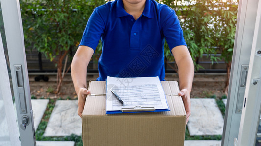 顾客男人检查或持有纸板包裹以便向接受交付箱件的客户发送信使货员验收或持有纸板包裹家图片