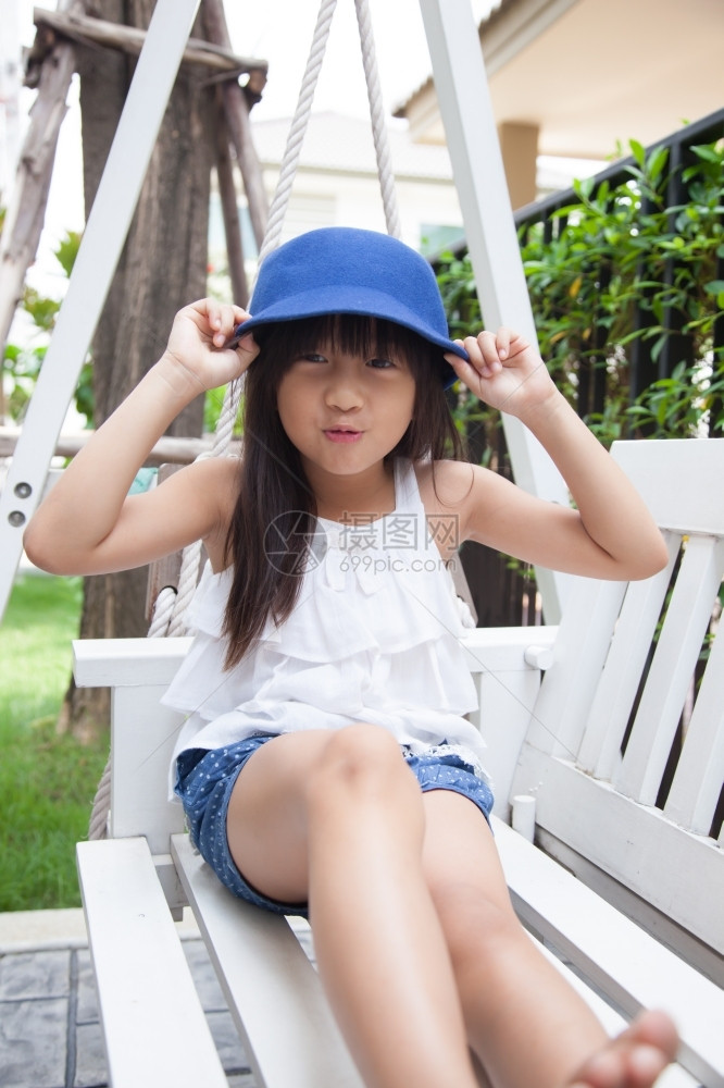 外部坐在摇摆手上的女孩拿着蓝色帽子笑蓝色的活动图片