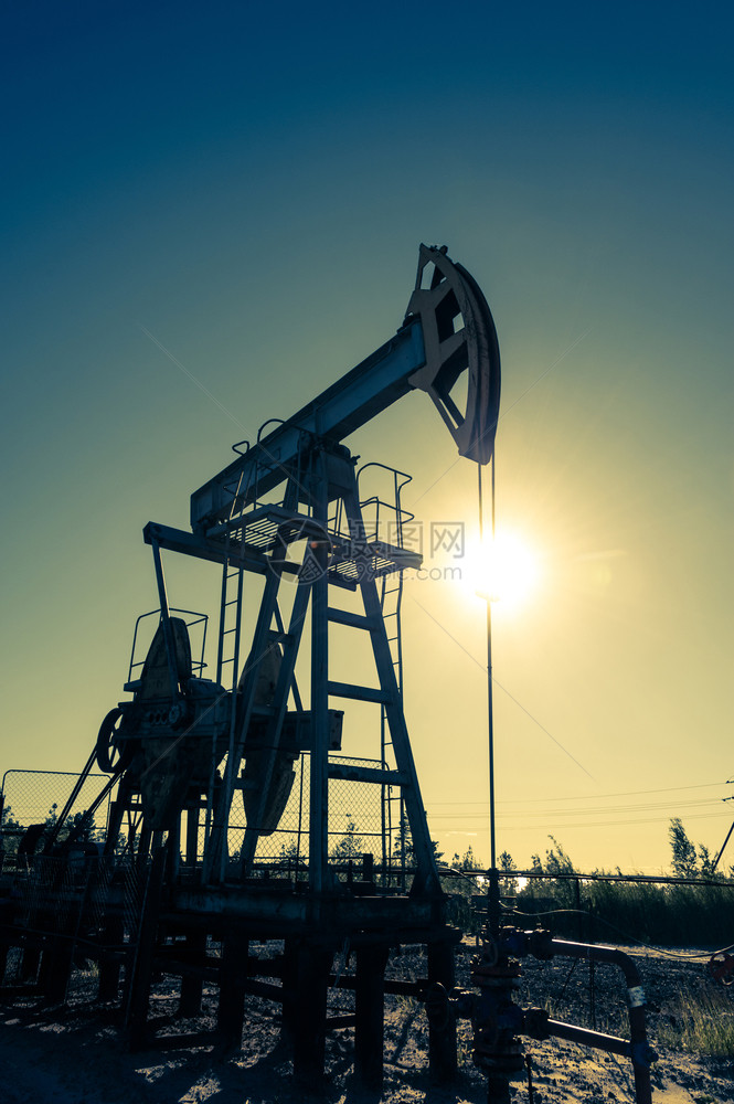 力量跑步油泵在日落天空背景的工业设备用于提取石油的摇摆机采矿石油概念泵工业设备采矿石油概念俄罗斯图片