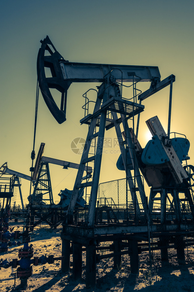 工业的阀门原油泵在日落天空背景的工业设备用于提取石油的摇摆机采矿石油概念泵工业设备图片