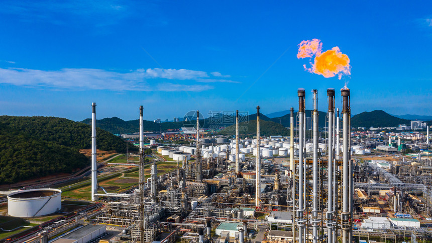 日间空中观察石油和天然气炼厂石化工在有火和蓝天背景的情况下工作日间观测机能和煤气炼油厂管子贮存技术图片