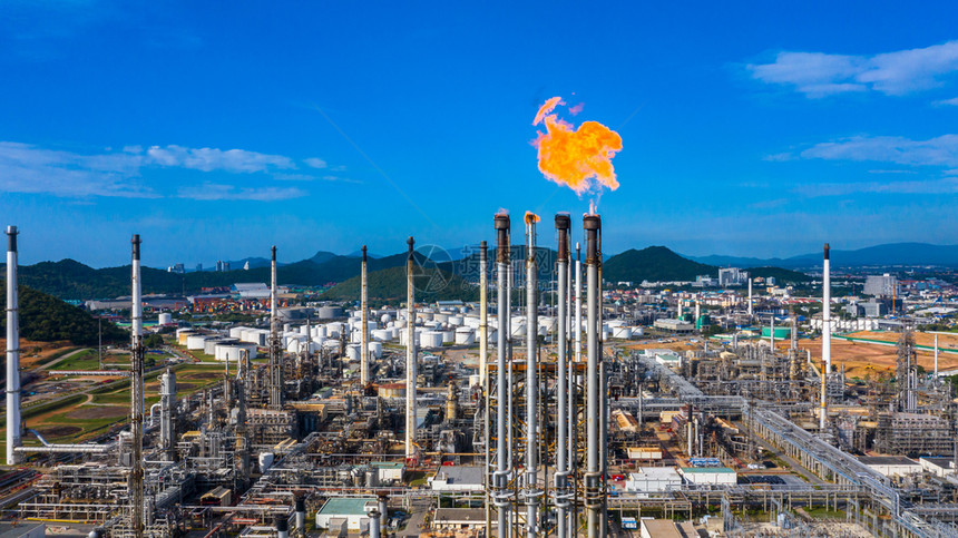 日间空中观察石油和天然气炼厂石化工在有火和蓝天背景的情况下工作日间观测机能和煤气炼油厂生产化学金属图片