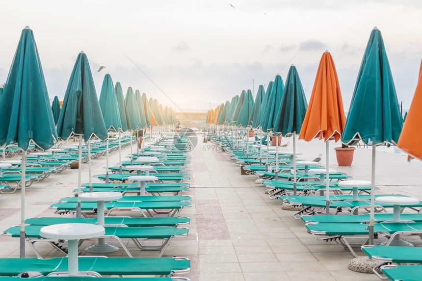 保加利亚杜尼暑假度胜地游泳池附近的绿色和橙雨伞太阳床保加利亚杜尼水色中央海滩图片