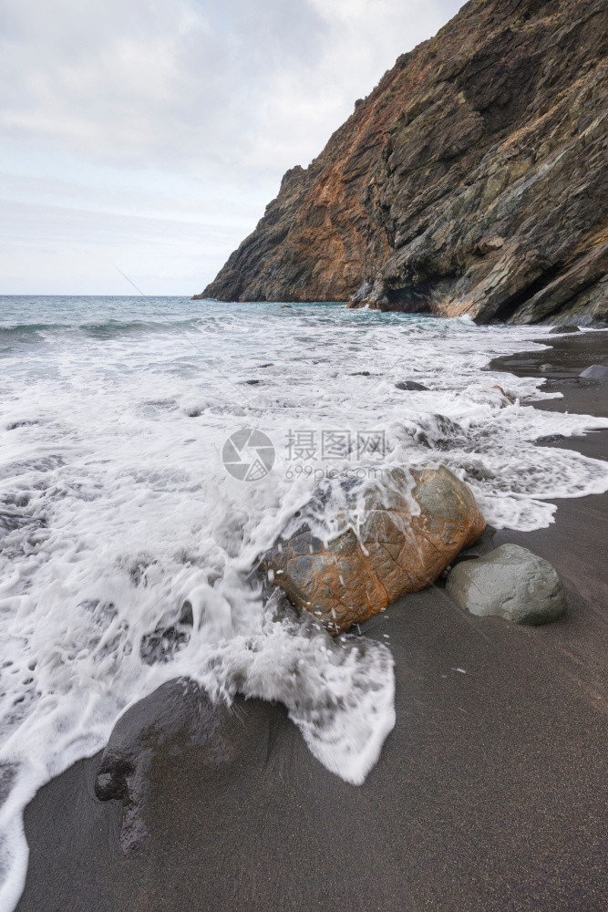 泡沫旅行在西班牙加那利群岛拉戈梅的暴风天在岩石海滩上喷洒波浪雾蓝色的图片